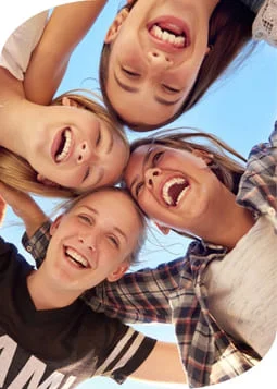 Four girls laughing together in a circle, enjoying each other's company and sharing a joyful moment.