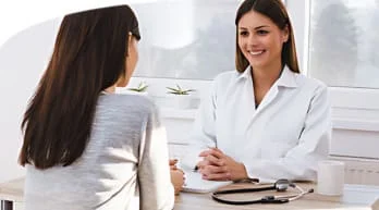 An image of a woman having a consultation with a doctor in a white coat.